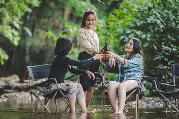 Group of women drink beer and soaked feet in stream