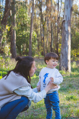 a young mother walks with her little son as a family with a maternity full of love childhood vertical