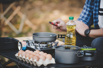 Asian traveler man glasses frying a tasty fried egg
