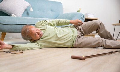 Asian old man lying on floor after falling down with wooden walking stick, Sick senior man beside...