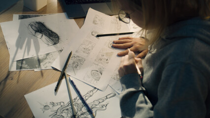 Female creative designer works on a storyboard and draws a sketches for a comic. Video editing,...