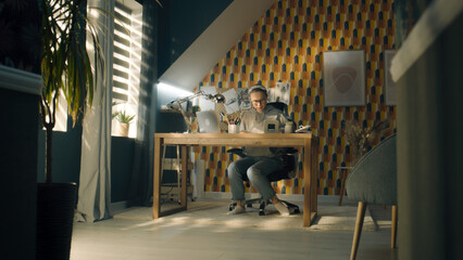 Focused illustrator draws sketches for her project. Young female artist with glasses dressed in a grey hoodie and sits on her work desk. Makes pencil sketches. Story telling concept.