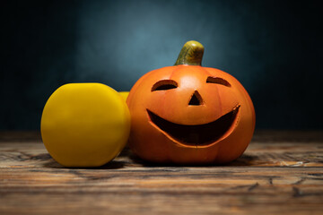 Small ceramic Halloween Jack-o'-lantern spooky figurine pumpkin and yellow dumbbell. Healthy...