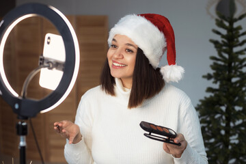 Diverse latin woman 30-35 years old streaming online in home studio decorated for christmas....