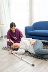Asian caregiver helping senior female from falling on the ground. Elderly older mature male having...