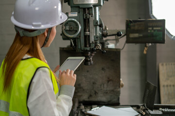engineer or factory worker using tablet computer for finding how to use machine control panel in factory
