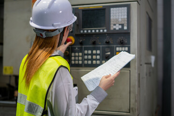 Industrial factory employee working and checking near electric meters panel of a control room in...