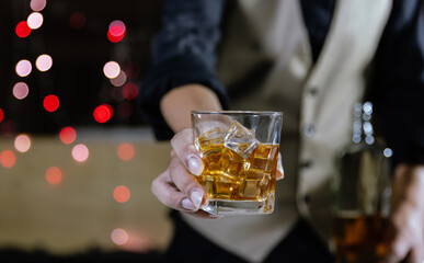 The bartender serves whiskey to customers at a bar or restaurant.