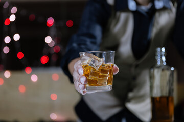 The bartender serves whiskey to customers at a bar or restaurant.