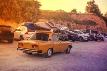 Crimea, an old retro car goes to the beach with SUP boards on the roof. Summer atmosphere