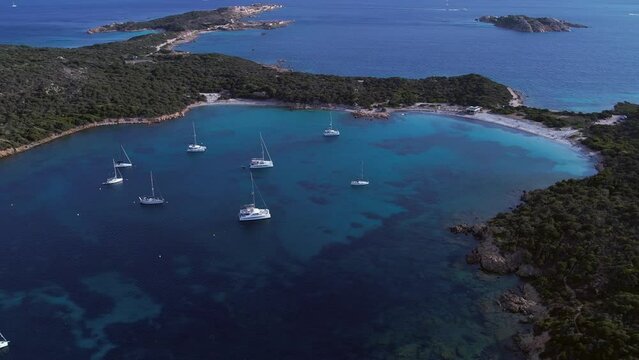 Expensive yachts moored in emerald colored bay on Caprera Island, Sardinia, Italy. Drone view.