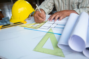 Architect designing project at Construction Site with blueprint