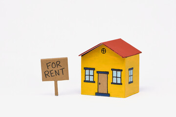 Yellow red toy cardboard house middle of frame isolated white background Realestate For Rent sign
