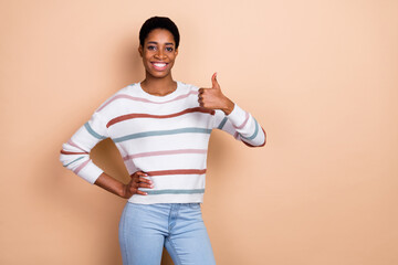 Photo of cute millennial brunette lady show thumb up wear white pullover isolated on beige color background