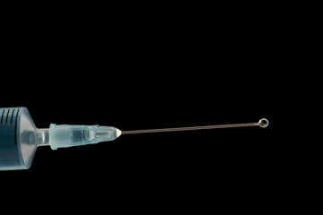Medical syringe showing blue liquid being expelled under pressure