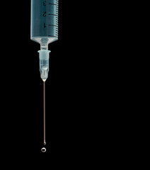 Medical syringe showing blue liquid being expelled under pressure