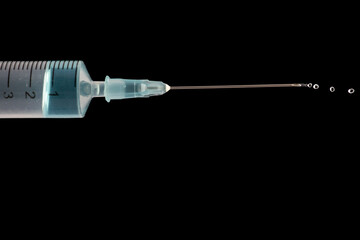 Medical syringe showing blue liquid being expelled under pressure