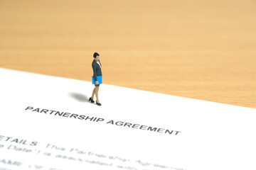 Fototapeta na wymiar Miniature people toy figure photography. Business partner contract sign concept. A businesswoman walking above partnership agreement file document