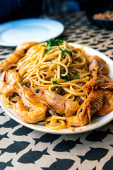 Italian pasta and big shrimps with tomato sauce served in white plate for a delicious meal