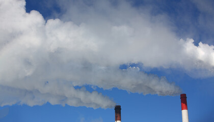 Chimney of factory plant against blue sky