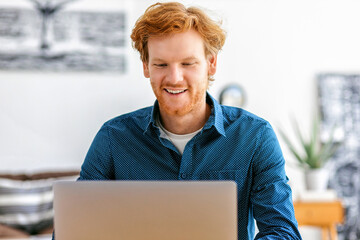 Happy businessman or freelancer working from modern office or at home using laptop