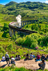 Vertical view of Glenfinnan Railway Viaduct seen by group of tourists in Scotland 