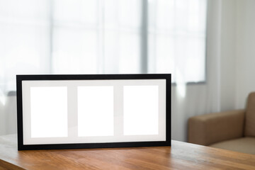 Style picture frame still life put on the wooden table in living room. Blank space empty picture frame with mockup. Natural light Template background interior design and decoration