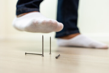 Nails placed on the floor risk an accident. A man was about to step on a nail. He was injured and...