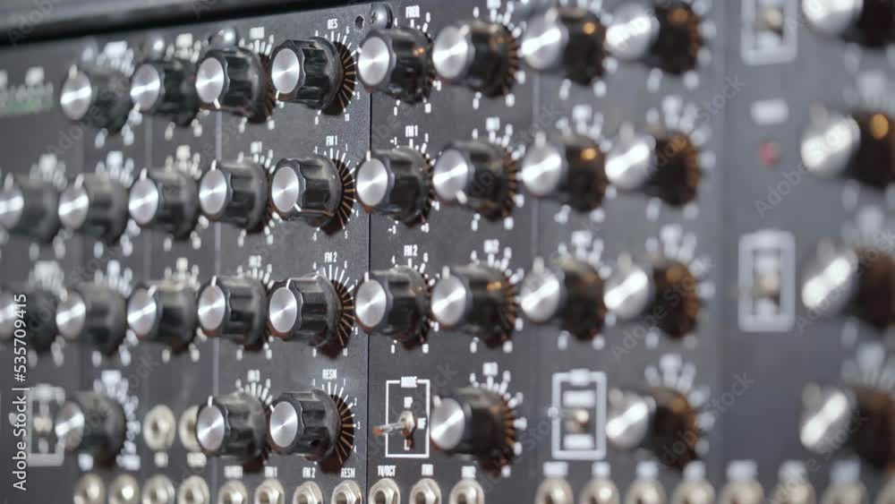 Poster streak of light on knobs of an audio mixing console in a recording studio. close up