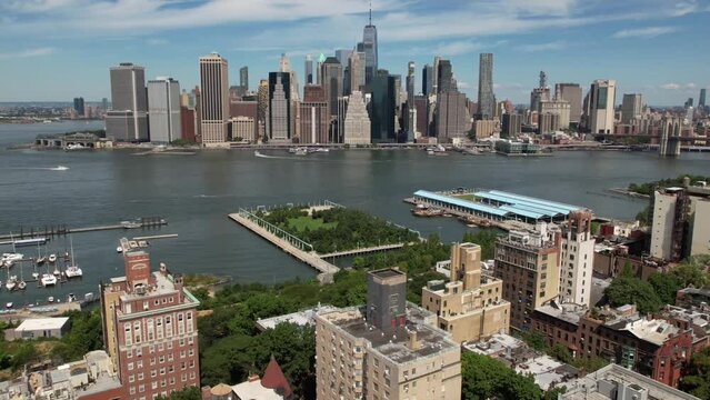 An aerial time lapse of Brooklyn, NY on a beautiful day with blue skies and white clouds. The camera dolly out over the residential neighborhood away from the financial district and the Freedom Tower.