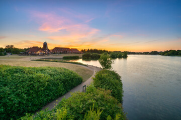 Fototapeta premium Old windmill on Caldecotte lake at sunset in Milton Keynes. England