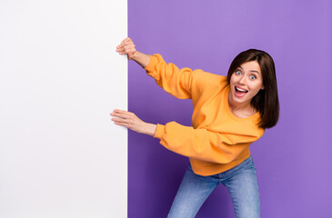 Photo of pretty cute optimistic lady wear orange stylish sweater hand hold empty space card poster...