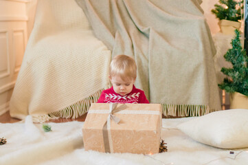 Little boy with a Christmas present in a room decorated for Christmas. Christmas mood