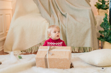 Little boy with a Christmas present in a room decorated for Christmas. Christmas mood