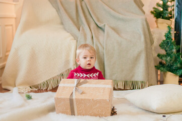 Little boy with a Christmas present in a room decorated for Christmas. Christmas mood