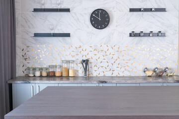 Stylish modern gray kitchen: spices in a jar, wine glasses on the shelves.