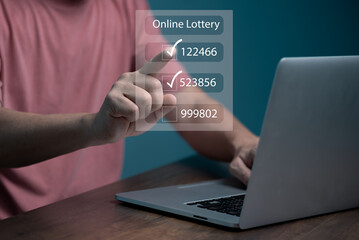 Obraz na płótnie Canvas Man using computer and touching on virtual Online lottery screen to buy two number set. 