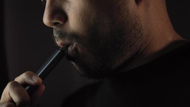 Close-up mouth of man smoke inhaling, breathing and smoke electronic cigarette.
