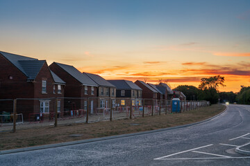 Obraz premium Row of new build houses under construction with sunset sky 