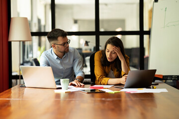 Colleagues in office. Businesswoman and businessman discussing work in office..