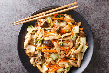 Delicious stir-fry of tender chicken and crunchy vegetables, chop suey close-up in a plate on the...