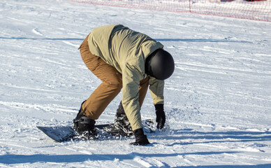 Fototapeta na wymiar A man slides down the mountain on a snowboard in the snow.