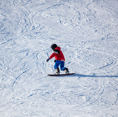 Fototapeta na wymiar A man slides down the mountain on a snowboard in the snow.