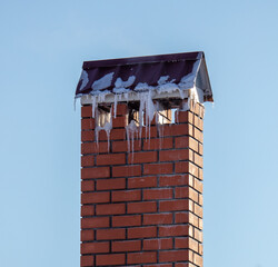 Ventilation pipe on the roof of a house with snow.