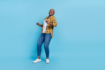 Fototapeta premium Full length photo of attractive funky woman dressed plaid shirt dancing having fun isolated blue color background
