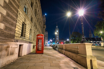 Red telephone booth and Big Ben at night in London. England