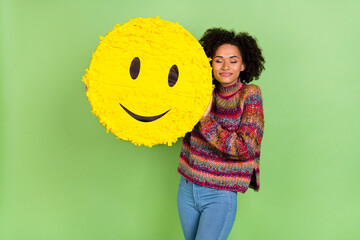 Photo of pretty dreamy woman wear striped sweater closed eyes holding smiley isolated green color...