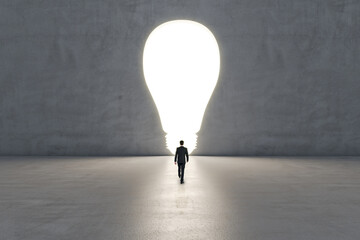 Obraz premium Innovation and creative idea concept with businessman back view goes towards illuminated hole in the form of light bulb on grey background