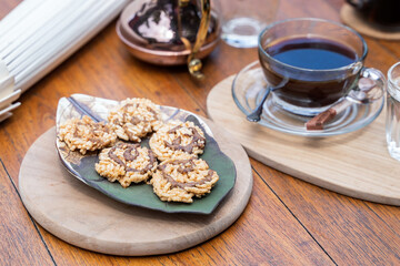 Sweet crispy rice cakes topping with cane sugar on plate and hot coffee in park. Thai snack.