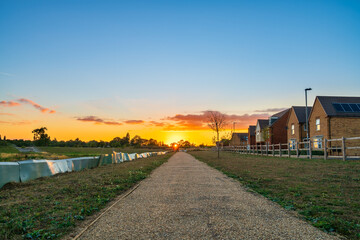 Fototapeta premium Empty walkway path at sunset near new build housing area in southern England